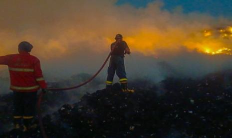 Petugas BPBD Kota Tangerang sedang memadamkan api di TPA Rawakucing yang terbakar. Pemkot Tangerang mengeklaim pemadaman TPA Rawakucing tinggal satu zona.