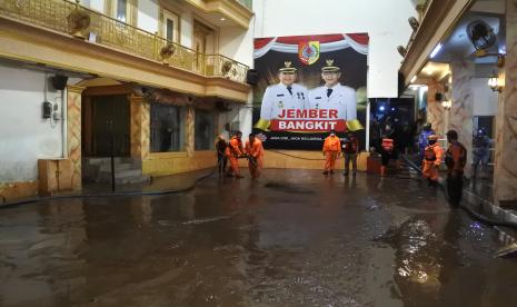 Petugas BPBD membersihkan lumpur usai banjir merendam rumah pribadi Bupati Jember Hendy Siswanto di Kecamatan Kaliwates, Jember, Jawa Timur, Senin (17/1/2022). Banjir merendam rumah pribadi bupati Jember dan puluhan rumah di sekitarnya dengan ketinggian satu meter akibat luapan Sungai Jompo setelah hujan deras mengguyur Jember selama lebih dari tiga jam.