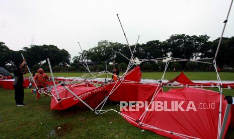 Petugas BPBD mengevakuasi tenda stan pameran UMKM yang berserakan akibat diterjang hujan disertai angin di Alun-Alun Kota Blitar, Jawa Timur,Ahad (5/11/2021). Puluhan tenda pameran UMKM tersebut rusak akibat diterjang hujan deras yang disertai angin kencang, dampak cuaca buruk di daerah itu.