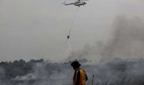 Petugas BPBD Provinsi Sumatera Selatan dibantu Helikopter MI-8Mtv milik Badan Nasional Penanggulangan Bencana (BNPB) melakukan pemadaman kebakaran lahan di Desa Rambutan, Banyuasin, Sumatra Selatan, Minggu (16/9). 