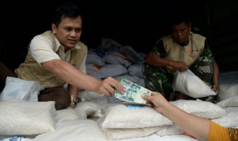 Petugas Bulog melakukan operasi pasar beras di kawasan Pasar Jatinegara, Jakarta Timur, Rabu (18/2).