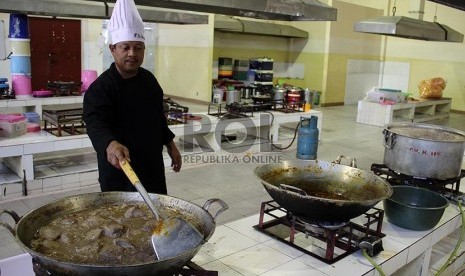 Petugas memasak makanan untuk makan jamaah haji.