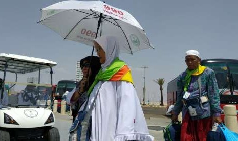 Petugas Daker Bandara memayungi jamaah lansia di Bandara Amir Muhammad bin Abdulaziz, Madinah. 