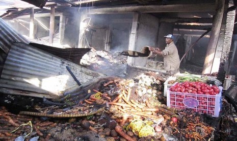 Pemilik kios berusaha memadamkan bara api di Pasar Lembang, Kabupaten Bandung Barat, yang hangus terbakar, Jumat (15/5).  (Republika/Edi Yusuf)