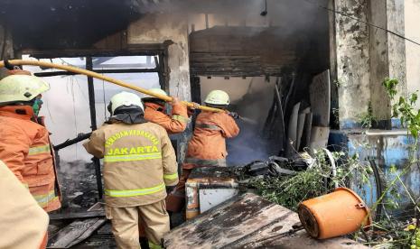 Petugas Damkar Jakarta Barat memadamkan kebakaran di pabrik kosong di kawasan Cengkareng Timur pada Sabtu (25/7) sekitar pukul 09.45 WIB.