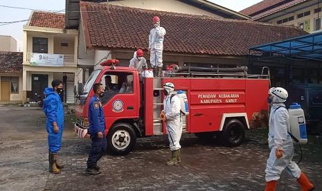 Petugas damkar melakukan penyemprotan disinfektan di Kantor Diskominfo Garut, Jumat (11/6).