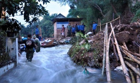  Petugas dan anggota Satgas Banjir Dinas Bina Marga dan Sumber Daya Air Depok masih kesulitan menutup tanggul Kali Laya yang jebol dini hari tadi di kawasan Cimanggis, Depok, Selasa (13/11). (Rakhmawaty La'lang)