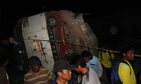 Petugas dan warga melihat lokomotif dari kereta api Eksekutif Bangunkarta jurusan Jakarta Surabaya yang terguling di Mundu, Cirebon, Jawa Barat, Sabtu (23/5) malam.