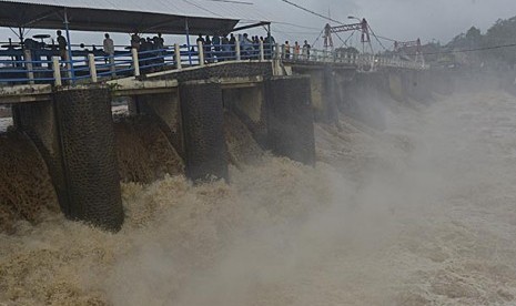 Petugas dan warga memantau ketinggian permukaan Kali Ciliwung di Bendung Katulampa, Bogor, Jabar, Selasa (21/1). Tinggi permukaan air di bendungan itu mencapai 170 cm atau Siaga II Banjir Jakarta, sehingga warga Jakarta harus waspada datangnya banjir, teru