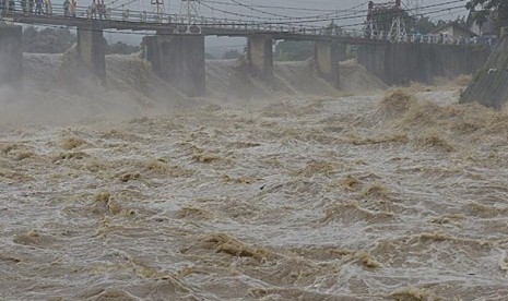 Petugas dan warga memantau ketinggian permukaan Kali Ciliwung di Bendung Katulampa, Bogor, Jabar, Selasa (21/1). Tinggi permukaan air di bendungan itu mencapai 170 cm atau Siaga II Banjir Jakarta, sehingga warga Jakarta harus waspada datangnya banjir, teru