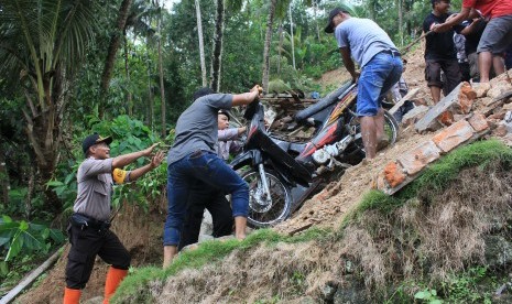 Petugas dan warga mengevakuasi kendaraan milik korban tanah longsor di Pacitan, Jawa Timur (ilustrasi).