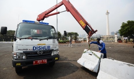 Petugas dari Dinas Perhubungan DKI Jakarta meletakan beton pembatas di silang Monas, Jakarta Pusat, Senin (28/9).  (Republika/Raisan Al Farisi)