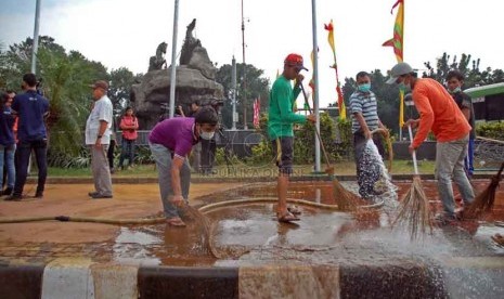 Petugas dari Dinas Pertamanan dan Pemakaman DKI Jakarta membersihkan sisa tanah dari taman yang rusak di Taman Bundaran Bank Indonesia, Jakarta Pusat, Jumat (22/8). (Republika/Raisan Al Farisi)