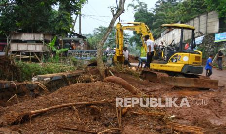 Petugas dari Dinas Pertamanan mengoperasikan alat berat untuk membersihkan puing-puing akibat banjir lumpur di Desa Srigading, Lawang, Malang, Jawa Timur, Rabu (9/3/2022). Hujan deras yang mengguyur kawasan tersebut menyebabkan bencana hidrometeorologi yakni longsor di badan jalan tol Malang-Pandaan serta banjir lumpur yang mengakibatkan satu orang tewas. 