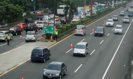  Petugas dari Kepolisian membantu mengatur arus lalu lintas di tol dalam kota di Kawasan Semanggi saat uji coba contra flow atau sistim melawan arus lalu lintas di Jakarta, Selasa (1/5). 