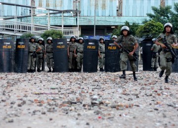 Petugas dari kepolisian membuat barikade untuk menghadang tawuran antar warga di kawasan pasar Rumput, Jakarta Selatan, Minggu (3/7). awuran tersebut mengakibatkan rusaknya fasilitas umum dan lalu lintas di Jl Sultan Agung macet berhenti total akibat peris