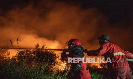 Petugas dari Manggala Agni Daops Banyuasin berusaha memadamkan kebakaran lahan di Desa Sungai Rambutan, Ogan Ilir (OI), Sumatera Selatan, Rabu (28/7/2021). Petugas gabungan dari TNI, Polri, BPBD Kab Ogan Ilir dan Manggala Agni Daops Banyuasin masih berupaya memadamkan kebakaran dilokasi tersebut.