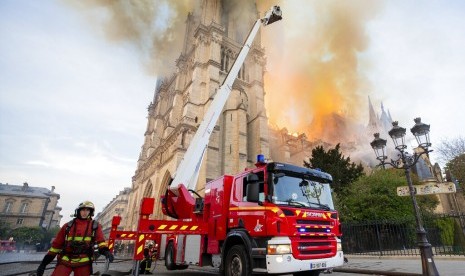 Petugas dari Paris Fire Brigade berusaha memadamkan api di Katedral Notre-Dame, Selasa (16/4). Gereja bersejarah berusia hampir 900 tahun itu terbakar pada Senin (15/4).