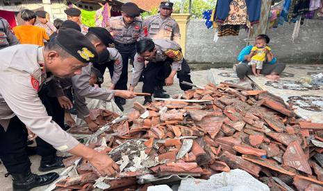 Petugas dari Polsek Juntinyuat dan Polres Indramayu terjun melakukan pembersihan puing-puing akibat bencana angin putting beliung di Kecamatan Juntinyuat, Kabupaten Indramayu, Jumat (5/1/2024). 