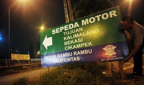 Petugas dari Satlantas Jakarta Timur, memasang rambu bantuan penunjuk arah jalan di kawasan Cawang, Jakarta, Rabu (31/7) malam. Rambu bantuan penunjuk arah ini ditujukan bagi para pemudik motor yang akan menuju Cikampek melewati ruas jalan Kalimalang, Beka