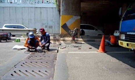 Petugas dari Suku Dinas Pekerjaan Umum Jalan, menyelesaikan perbaikan drill jalan yang jebol di underpass Blok A, Tanah Abang, Jakarta Pusat, Selasa (15/7). (Republika/Raisan Al Farisi)