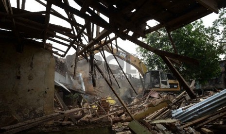 Petugas dengan alat berat merobohkan bangunan saat penggusuran pemukiman liar di Kampung Pulo, Jatinegara, Jakarta, Kamis (20/8).