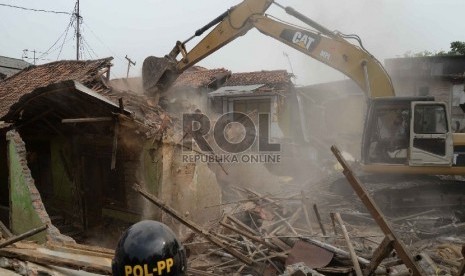 Petugas dengan alat berat merobohkan bangunan saat penggusuran pemukiman liar di Kampung Pulo, Jatinegara, Jakarta, Kamis (20/8).