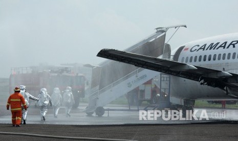 Petugas dengan pakaian khusus memasuki pesawat pada Emergency Exercise (Simulasi Keadaan Darurat) Tahun 2017 yang digelar PT Angkasa Pura II di Bandara Husein sastranegara, Kota Bandung, Kamis (16/11).