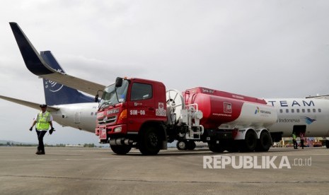 Petugas Depot Pengisian Pesawat Udara (DPPU) PT. Pertamina dengan menggunakan mobil tangki mengisi bahan bakar minyak Avtur untuk salah satu pesawat komersil di Bandara Internasional Sultan Iskandar Muda, Aceh Besar, Aceh, Selasa (1/8). 