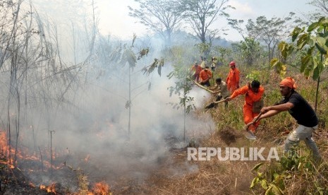 Petugas di bantu warga sekitar memadamkan api di lahan gambut (ilustrasi) 