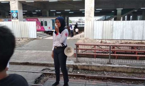 Petugas di Stasiun Manggarai, Jakarta membawa megaphone portabel dan berjaga di titik penyeberangan untuk memberitahu penumpang tentang perubahan jalur, Senin (13/8).