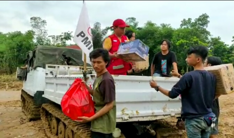 Petugas dibantu warga mengambil bantuan yang disalurkan untuk warga terdampak banjir yangh diangkut menggunakan hagglunds 