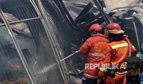 Petugas Dinas Kebakaran (Damkar) berupaya sisa api sebuah gedung yang terbakar (ilustrasi)