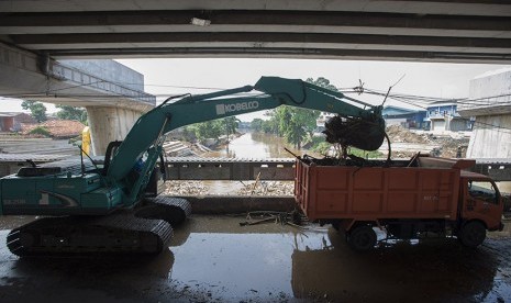 Petugas Dinas Kebersihan DKI Jakarta mengoperasikan ekskavator untuk memindahkan sampah yang terbawa arus Sungai Ciliwung. (Ilustrasi)