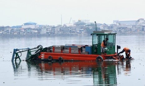 Petugas Dinas Kebersihan mengangkut sampah yang menyangkut pada baling-baling kapal berky, di Waduk Pluit, Jakarta Utara, DKI Jakarta, Senin (12/11/2018).