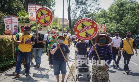 Petugas Dinas Kesehatan dan Dinas Perdagangan berkeliling pasar dengan membawa poster himbauan untuk mengenakan masker saat kegiatan Ronda Masker di Pasar Legi, Solo, Jawa Tengah, Jumat (18/9/2020). Ronda masker tersebut untuk himbauan pedagang sekaligus pengunjung untuk selalu mengenakan masker dan mematuhi protokol kesehatan saat beraktifitas di dalam pasar untuk mencegah penularan COVID-19.