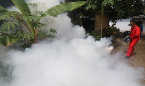 Petugas Dinas Kesehatan melakukan pengasapan (fogging) di permukiman warga untuk mengendalikan perkembangbiakan nyamuk penyebaran virus dengue. 