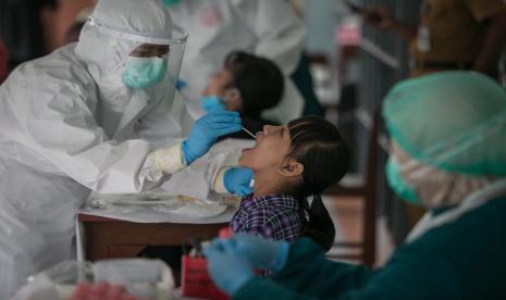 Petugas Dinas Kesehatan mengambil sampel lendir hidung dan tenggorokan siswa yang kontak erat dengan siswa terkonfirmasi positif COVID-19 untuk dilakukan tes Swab PCR di SD Marsudirini, Solo, Jawa Tengah, Senin (7/2/2022).