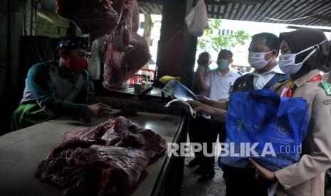 Petugas Dinas Kesehatan Provinsi Sumatra Selatan bersama anggota Pramuka melakukan sosialisasi penegakan protokol kesehatan, di Pasar Palima Palembang, Sumsel, Rabu (3/2/2021). Sosialisasi yang dilakukan di sejumlah titik pasar di Kota Palembang ini bertujuan untuk menekankan penegakkan protokol kesehatan di lingkungan pasar sekaligus memberikan edukasi tentang pentingnya vaksin COVID-19.