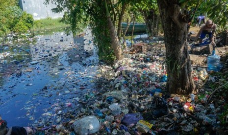 Petugas Dinas Lingkungan Hidup (DLH) membersihkan sampah di sekitaran Sungai Loji yang berwarna hitam akibat pencemaran limbah batik di Pekalongan, Jawa Tengah, Selasa (23/7/2019). 