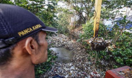 Petugas Dinas Lingkungan Hidup Kabupaten Bogor membersihkan sampah yang menumpuk menggunakan alat berat di Kali Baru, Cibinong, Kabupaten Bogor, Jawa Barat, Kamis (26/8/2021). Kegiatan tersebut untuk mengurangi sampah di sungai dan mencegah bencana banjir. 