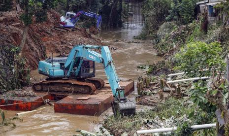 Petugas Dinas Pekerjaan Umum dan Penataan Ruang mengoperasikan alat berat untuk mengangkut sampah dan lumpur yang menumpuk di aliran sungai Kali Baru, Cibinong, Kabupaten Bogor, Jawa Barat, Senin (10/10/2022). Normalisasi sungai tersebut sebagai langkah antisipasi banjir di musim hujan. 