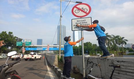 Petugas Dinas Perhubungan DKI Jakarta mencopot rambu yang mengecualikan pengguna sepeda road bike (sepeda balap) di Jalan Layang Non-Tol Kampung Melayu-Tanah Abang alias JLNT Casablanca, kawasan Tebet, Jakarta Selatan, Ahad (13/6). Pencopotan dilakukan setelah adanya protes dari koalisi LSM.