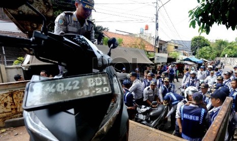  Petugas Dinas Perhubungan DKI Jakarta mengangkut motor yang nekat parkir di bahu jalan di Kawasan Kebon Kacang, Tanah Abang, Jakarta Pusat, Senin (12/10).   (Republika/Yasin Habibi)