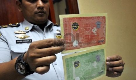   Petugas Dinas Perhubungan DKI Jakarta menunjukkan stiker ganjil genap berhologram di Jakarta, Kamis (7/3).   (Republika/Prayogi)