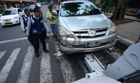  Petugas Dinas Perhubungan DKI Jakarta merazia pengemudi yang parkir sembarangan di depan Stasiun Cikini, Jakarta Pusat, Selasa (24/2).  (Republika/Raisan Al Farisi)