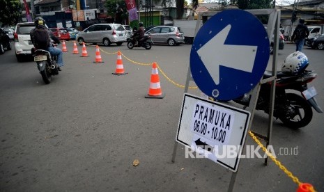 Petugas Dinas Perhubungan mengarahkan kendaraan saat di berlakukannya uji coba rekayasa lalul intas di simpang Jalan Proklamasi, Jakarta, Kamis (8/6).