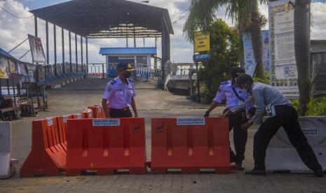 Petugas Dinas Perhubungan menutup jalur masuk ke Dermaga Feri Alalak di Banjarmasin, Kalimantan Selatan, Selasa (11/5/2021). Jalur penyeberangan kapal feri tradisional antar kabupaten/kota tersebut ditutup mulai tanggal 11-16 Mei 2021 guna membatasi tingginya arus keluar masuk orang dalam upaya mencegah peningkatan penyebaran COVID-19 di wilayah Kota Banjarmasin saat hari raya Idul Fitri 1442 H.