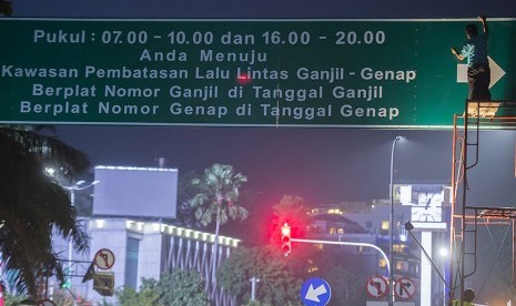 Petugas Dinas Perhubungan menyelesaikan pekerjaan pemasangan papan informasi penerapan sistem ganjil dan genap di Jalan Kebon Sirih, Jakarta, Sabtu (27/8).