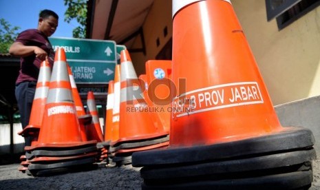   Petugas dinas perhubungan provinsi Jawa Barat mempersiapkan sejumlah rambu-rambu dan pembatas jalan di Simpang Tomo, Sumedang, Jawa Barat, Senin (29/7).   (Republika/Prayogi)